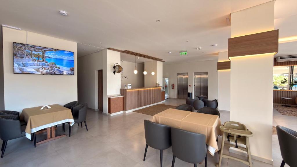 a dining room and living room with a table and chairs at Di Garda Hotel in Encarnación