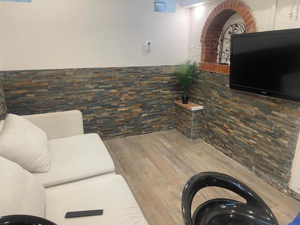 a living room with a couch and a flat screen tv at Small renovated cozy spot in Palavas-les-Flots