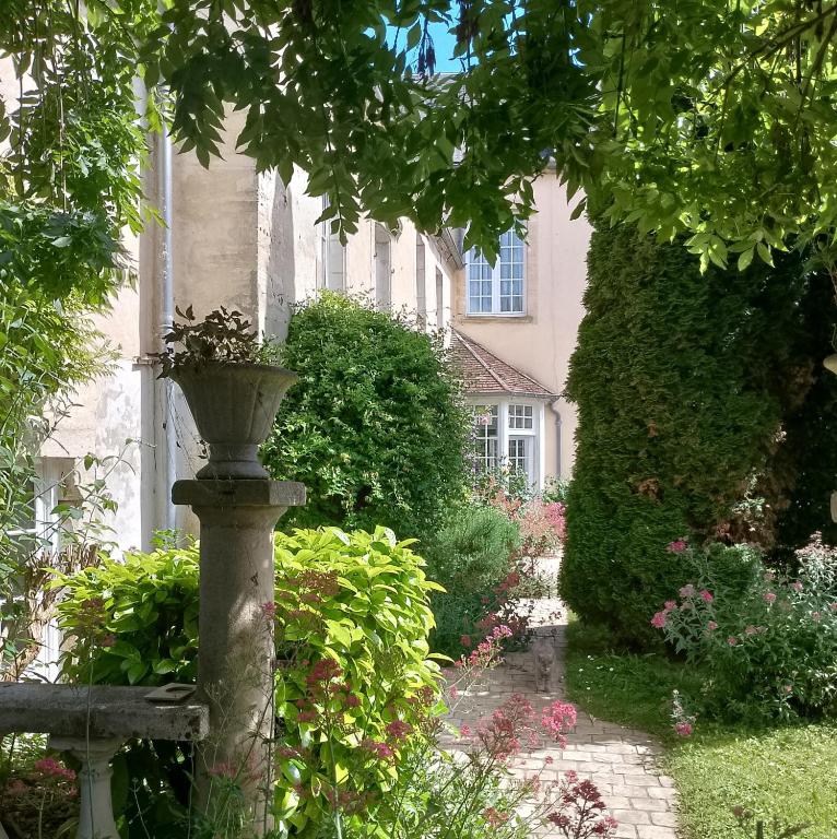 a garden with a planter in front of a building at Gîtes de france le cosy saint pierre in Sées
