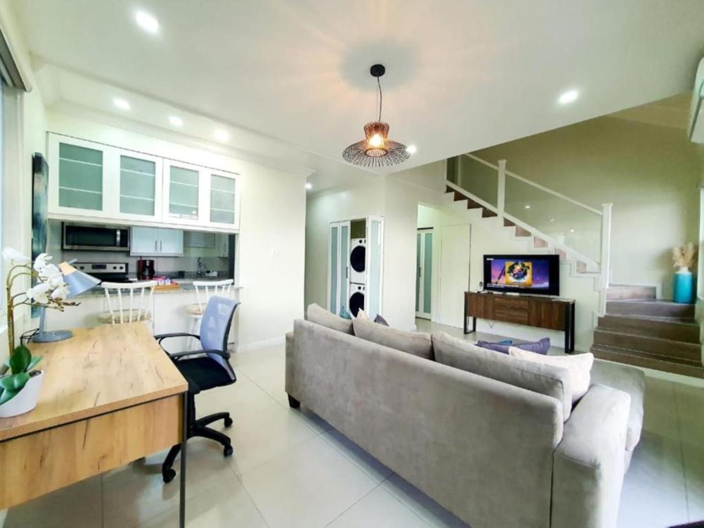 a living room with a couch and a table at Choose To Be Happy at EI8HT - Super Studios and 1-BR Penthouse Apartment in Kingston