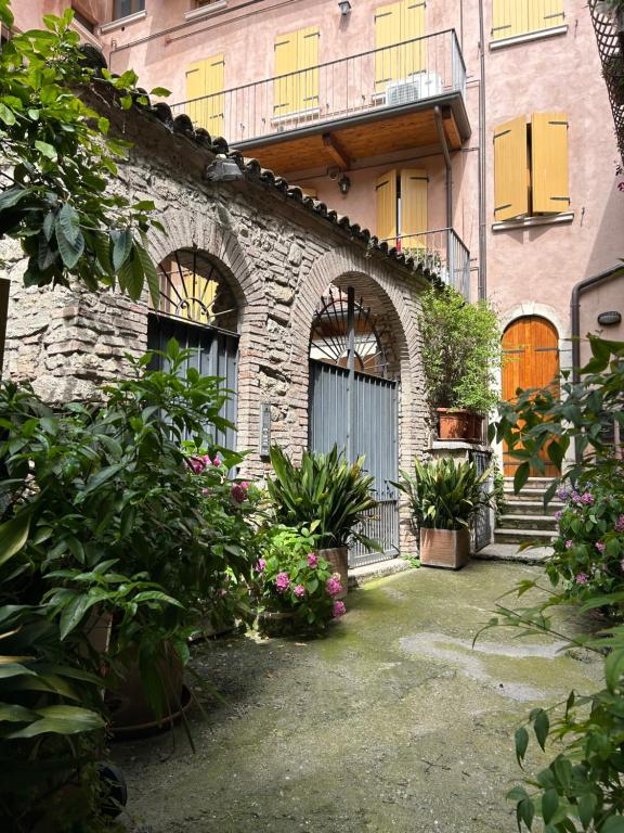 a stone building with a bunch of plants and flowers at Mirella house Desenzano del Garda -Centro storico, 30 mt dal lago in Desenzano del Garda