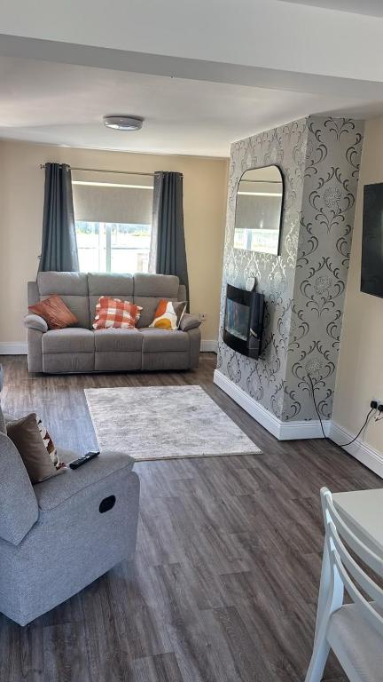a living room with a couch and a fireplace at Deel Manor in Eas Géitine