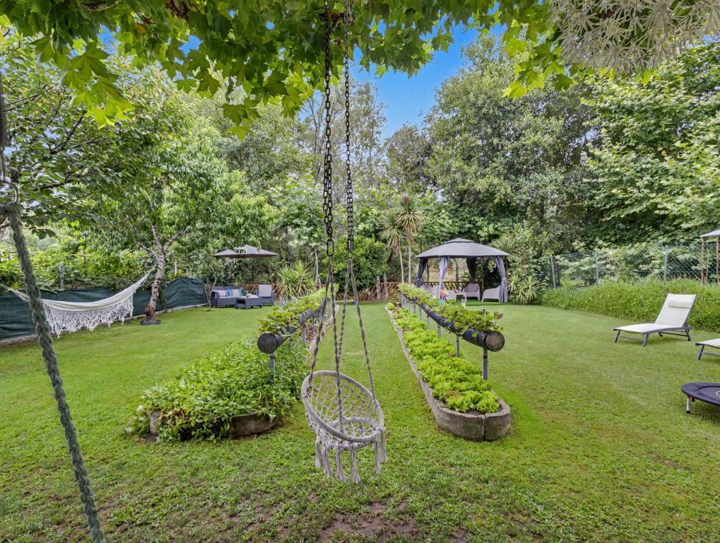 a garden with a row of plants and a bench at Casa da Moleira in Amares