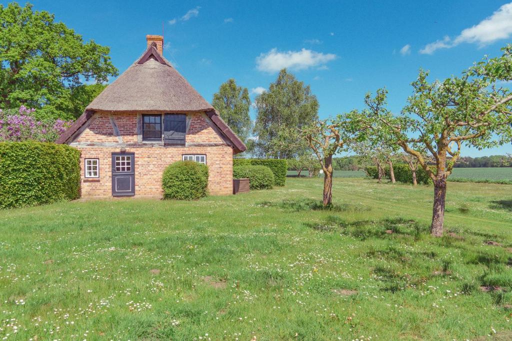 an old brick house in a field with trees at Ferienwohnung Hasenkate II - Boldevitzer Rügenkaten in Parchtitz