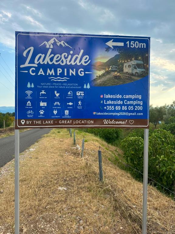 a blue sign on the side of a road at LakeSide Camping in Koplik