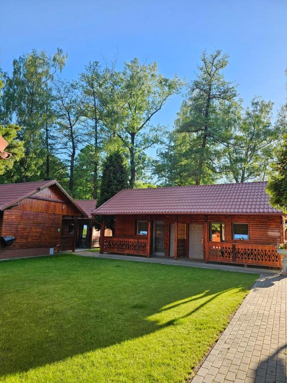 a house with a green lawn in front of it at Bajkowa Przystań in Pokrzywna