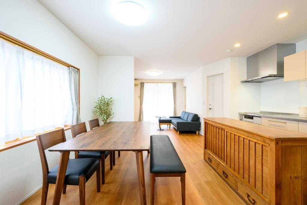 una cocina y comedor con mesa y sillas de madera en KOAのお宿 ー Koa no Oyado ー, en Gujō