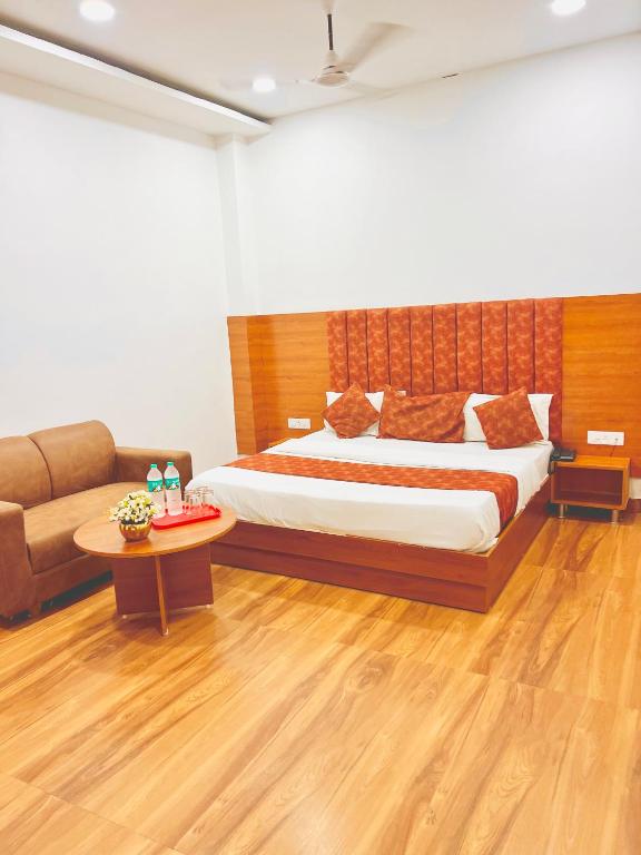 a bedroom with a bed and a couch at Hotel Grand Royal Sandhu in Amritsar