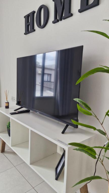 a tv on a white tv stand with a television at Apart Origenes 1 in Villa Regina