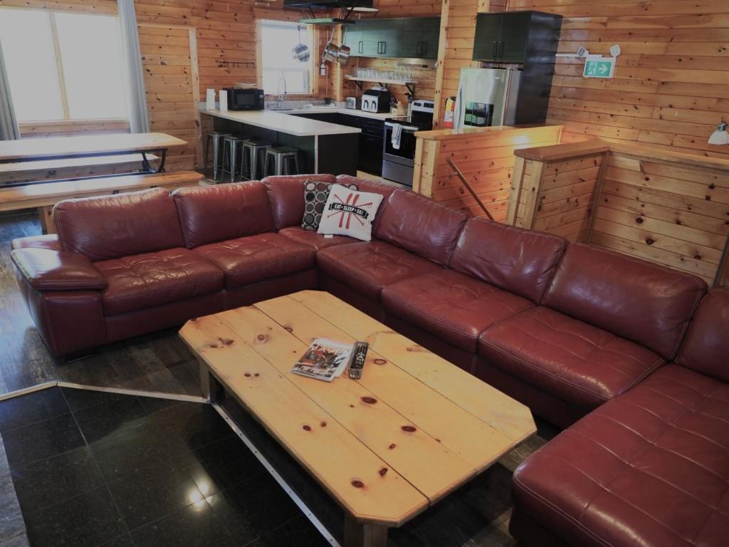a brown leather couch with a coffee table in a kitchen at Renovated 6 Bedroom Chalet Hot Tub Near Village in Blue Mountains
