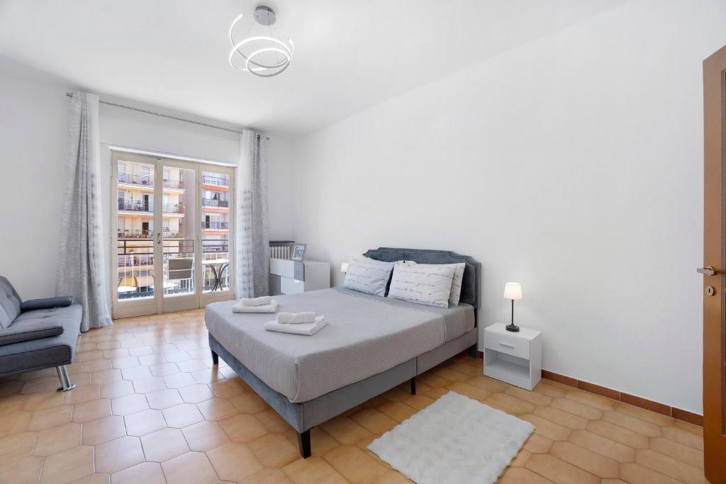 a bedroom with a bed and a couch and a chair at Appartamento Isabella in Verbania