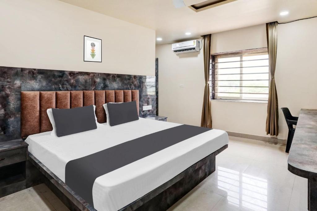 a bedroom with a large bed and a table at Hotel O SWEDHA HOTEL in Hazārībāg