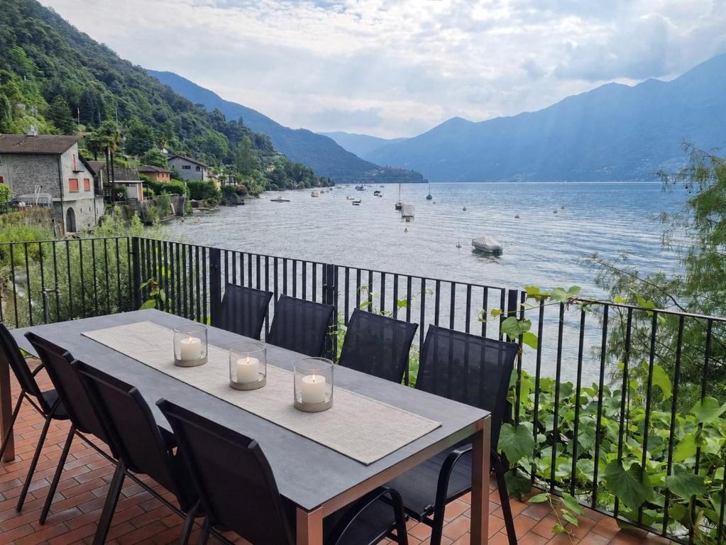 a table on a balcony with a view of a body of water at Casa Andrea Chefétage by Fewotessin in Gerra