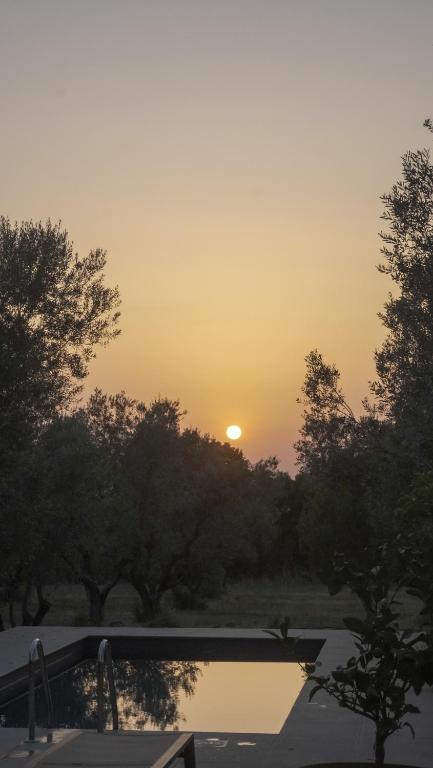 a sunset over a pond with the sun in the sky at Casa YUVI in Vetralla