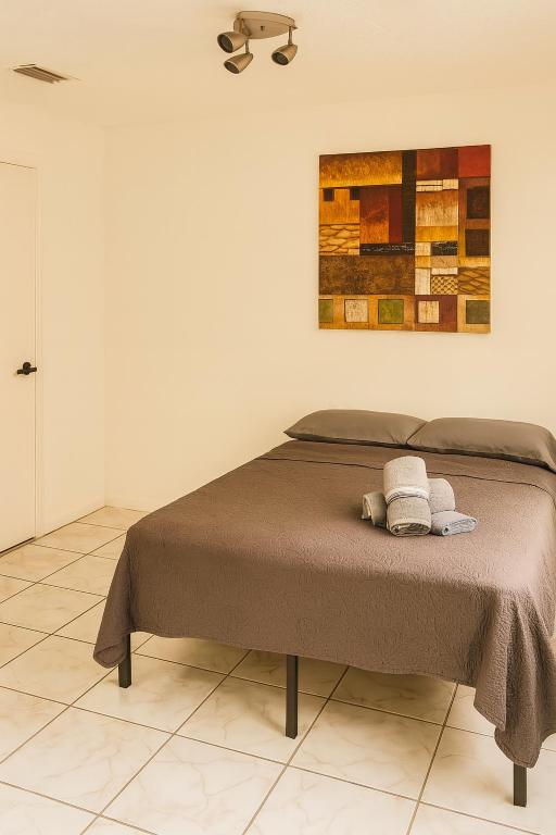a bed in a bedroom with a painting on the wall at Fauna Beach in Gold Coast Heliport