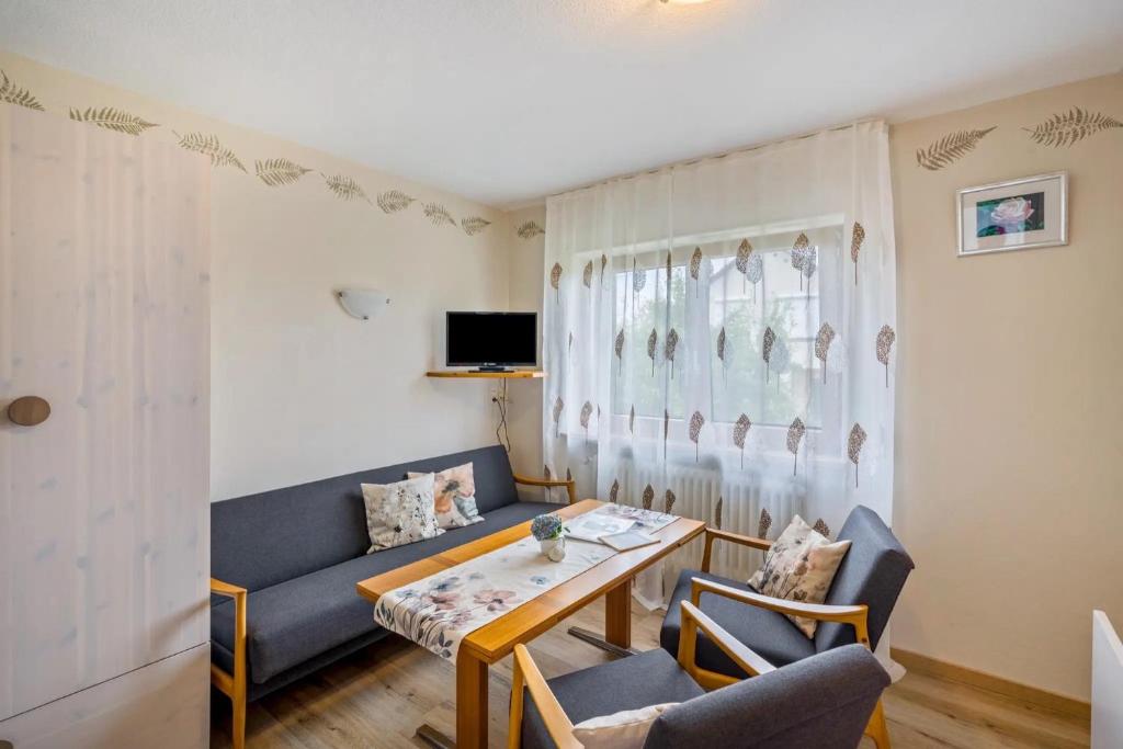 a living room with a couch and a table and chairs at Apartment Abendrot in Freiamt