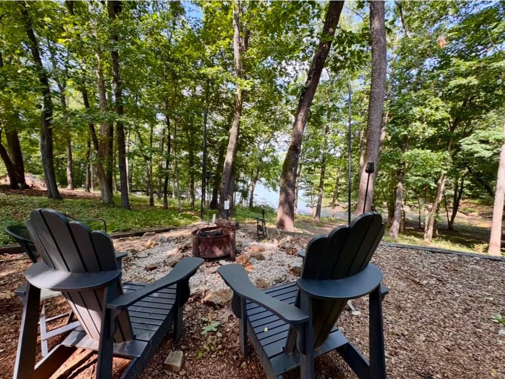 two chairs sitting next to a campfire in the woods at Pine Bluff on the Lake in Golden