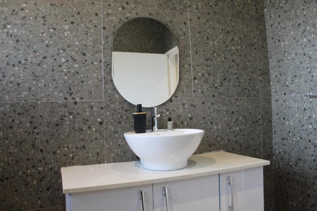 a bathroom with a white sink and a mirror at Kanyane @ Graskop in Graskop