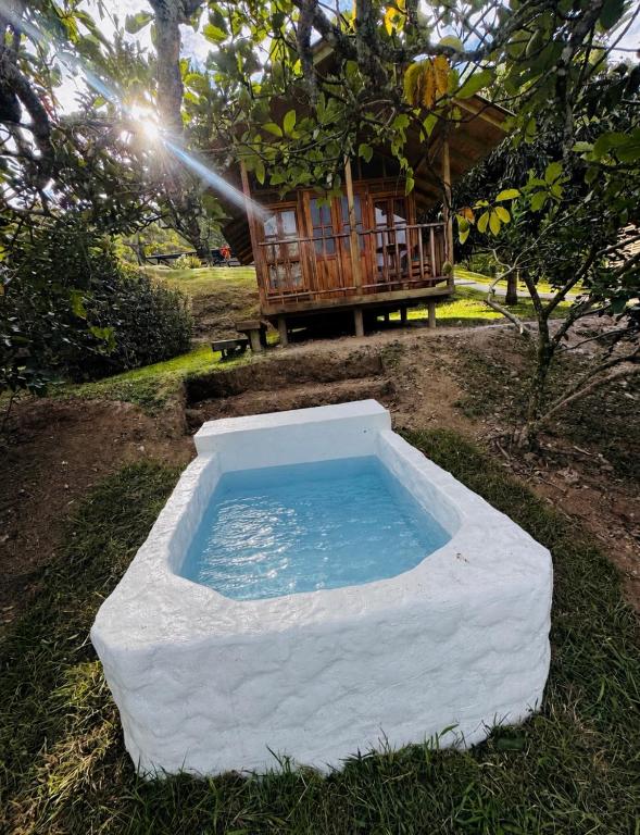 a large white pool of water in front of a house at Finca Villa Julia - Cabañas in La Vega