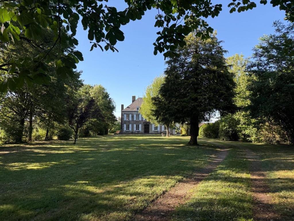 a large house with a tree in the middle of a field at Château Talence 1870 in LʼAbsie