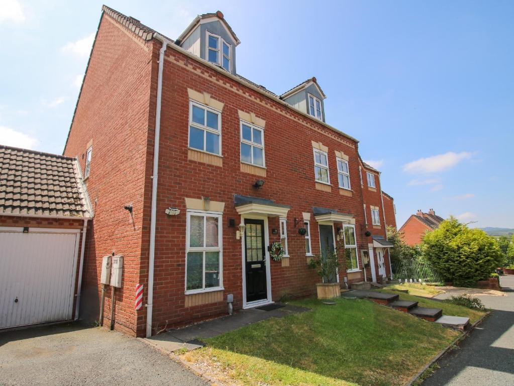 a red brick house with a garage at 18 Hengrave Meadow in Telford
