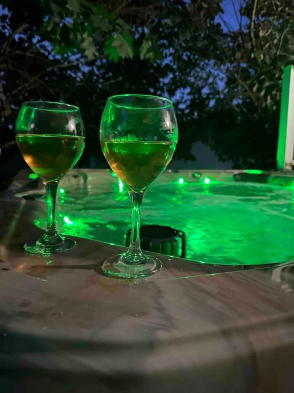two wine glasses sitting on a table next to a swimming pool at Be our Guest in Sevierville