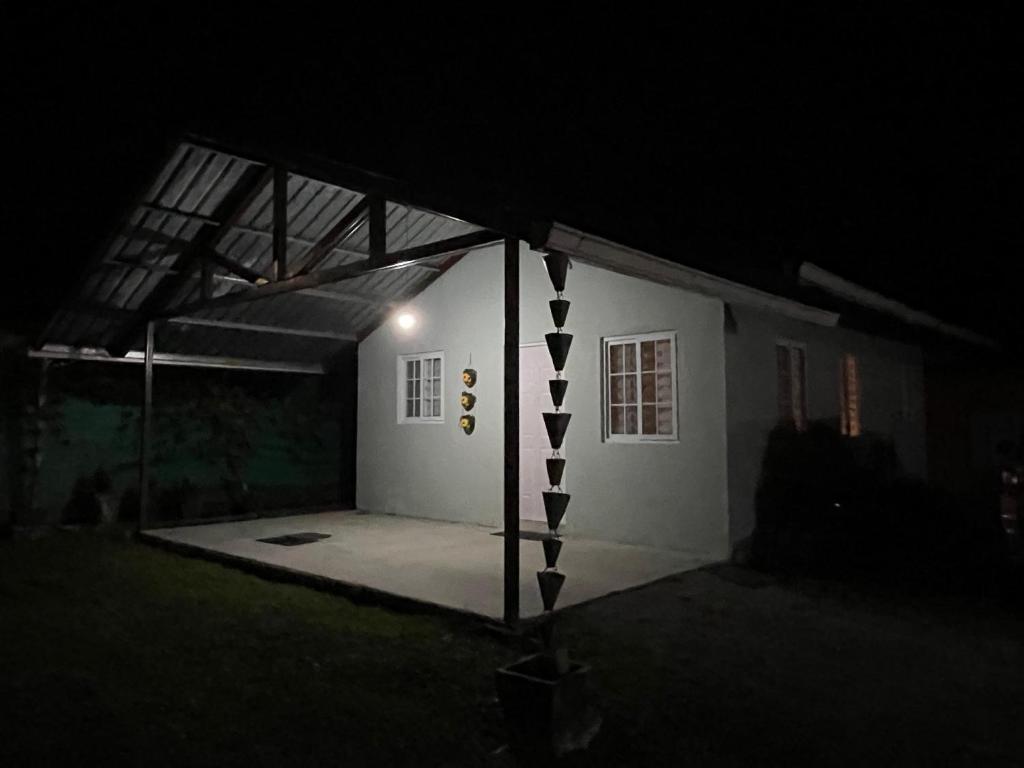 a small white building with a lit up garage at night at Casa Colibrí Volcán in Volcán