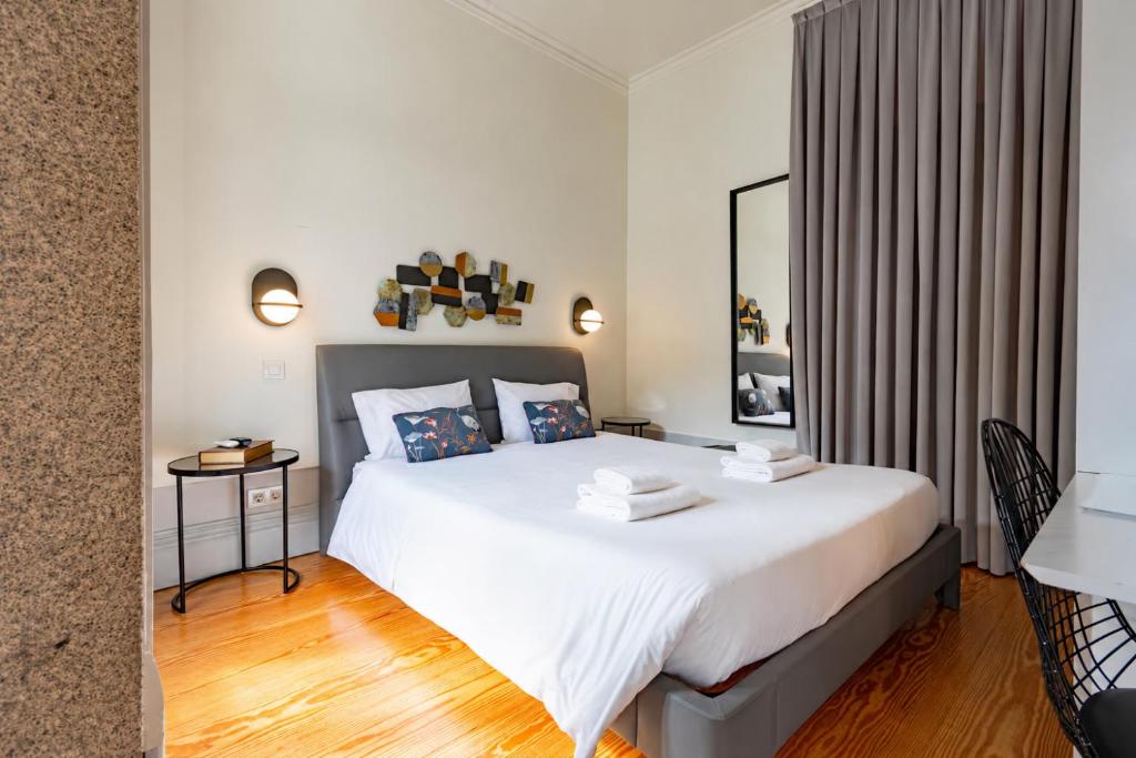 a bedroom with a large white bed in a room at Mouzinho 226 in Porto