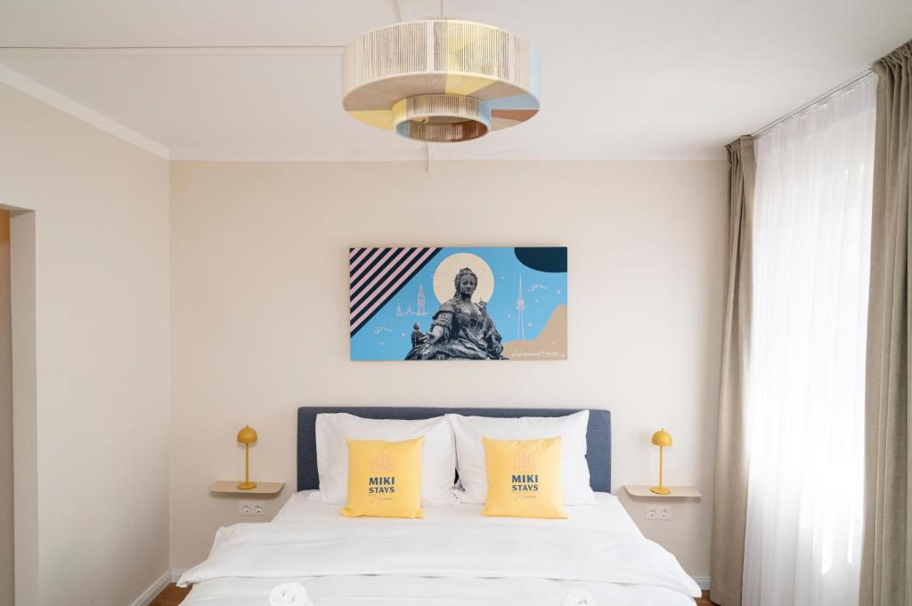 a bedroom with a white bed with yellow pillows at Miki Stays - 200m zum Prater in Vienna