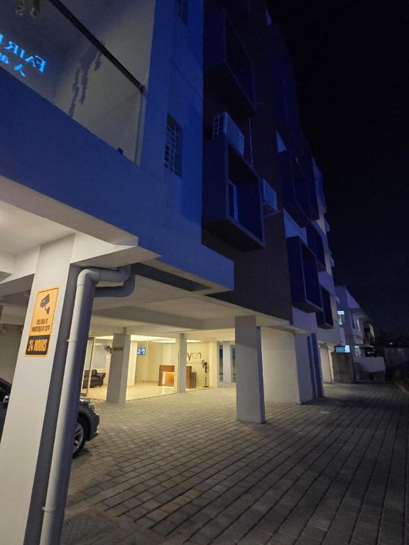 a blue and white building with a parking lot at night at viyan stays in Coimbatore