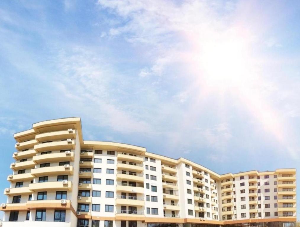 a large apartment building with the sun in the sky at Panamera Luxury Apartment Ilidža in Sarajevo