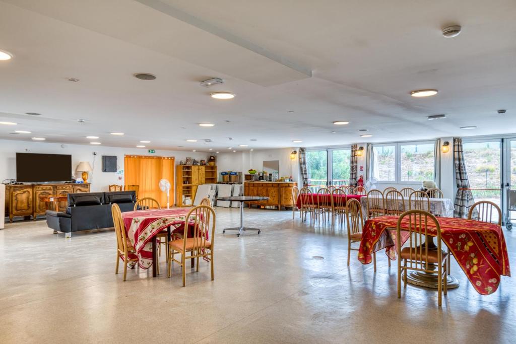 a room with tables and chairs with red table cloth at Résidence Arkenciel 1 in Mudaison