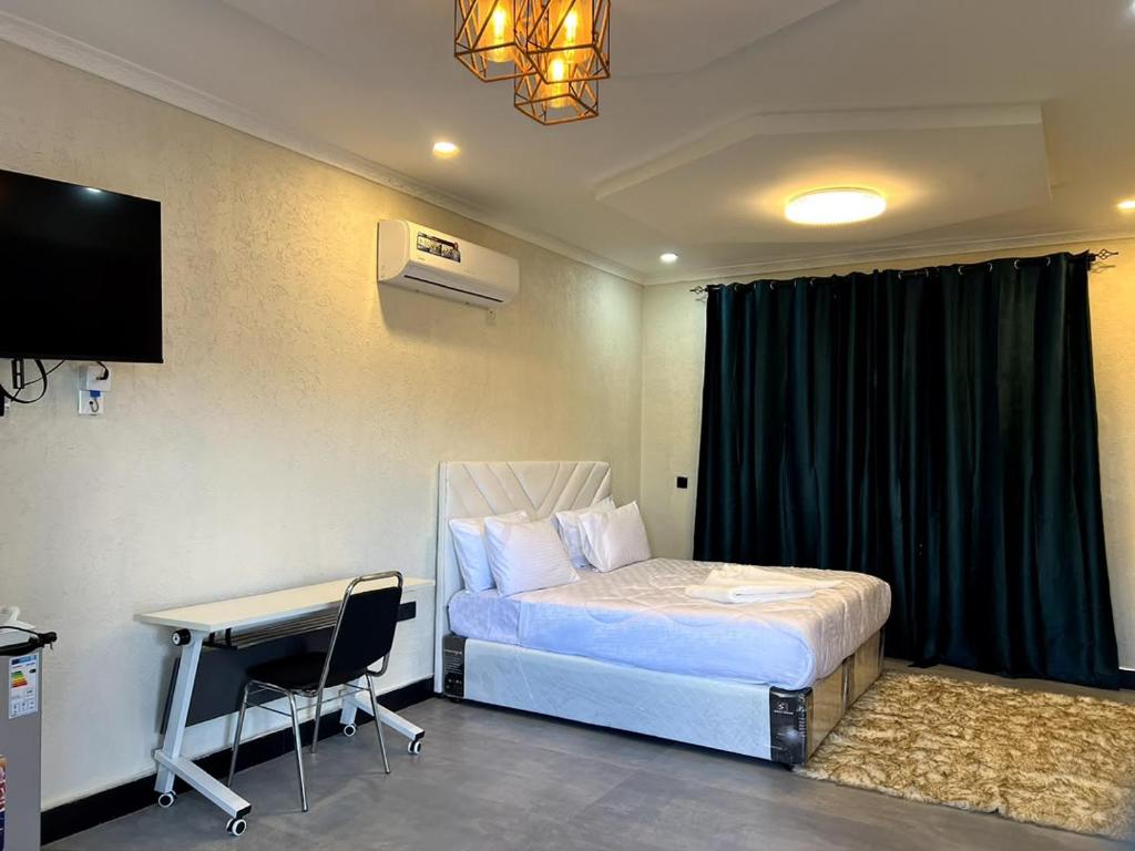 a bedroom with a bed and a desk and a television at Ravens nests lodge in Livingstone