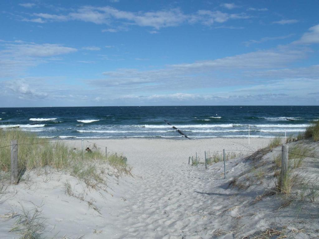 a sandy beach with the ocean in the background at Ferienwohnung _ Kartenraum _ Objek in Warnemünde