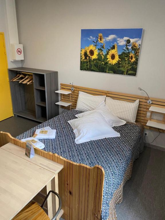 a bedroom with a bed with a painting on the wall at La Maison Lourégo studio Tournesol in Hauterives