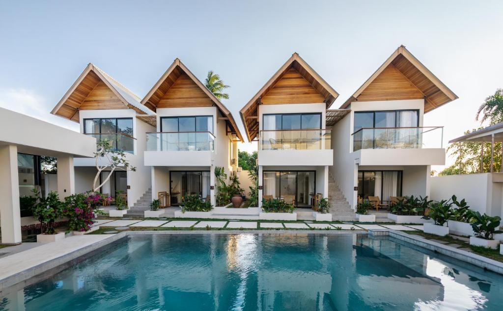 an exterior view of a house with a swimming pool at FinnKai Villas in Sengkol