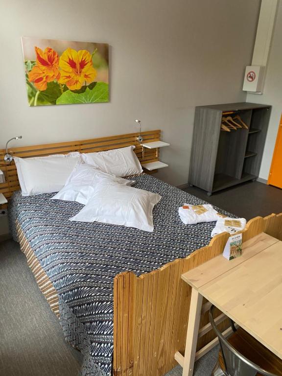 a bedroom with a large bed with a table and a painting at La Maison Lourégo studio Capucine in Hauterives