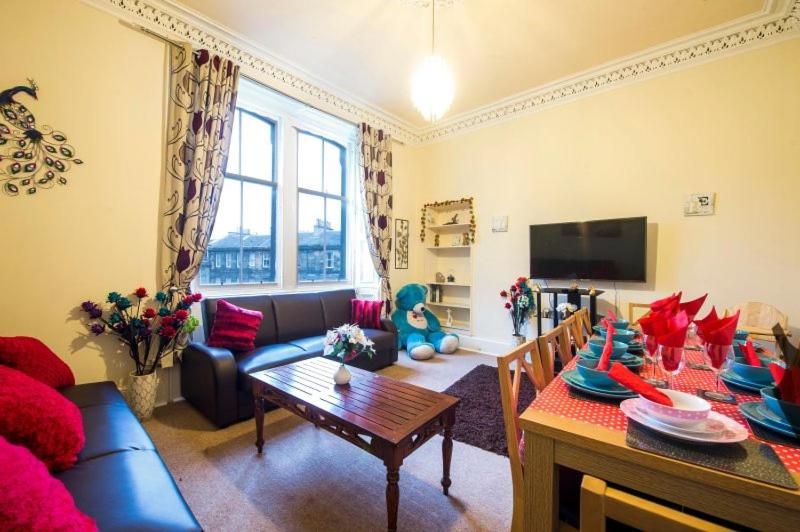 a living room with a couch and a table at Edinburgh Morrison Central ApartHotel in Edinburgh