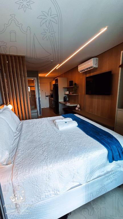 a large white bed in a room with a television at Refúgio Azul de Porto in Porto De Galinhas