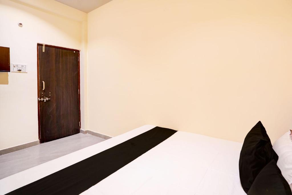 a room with a bed with a wooden door at HOTEL O S S STAY INN in Nagpur