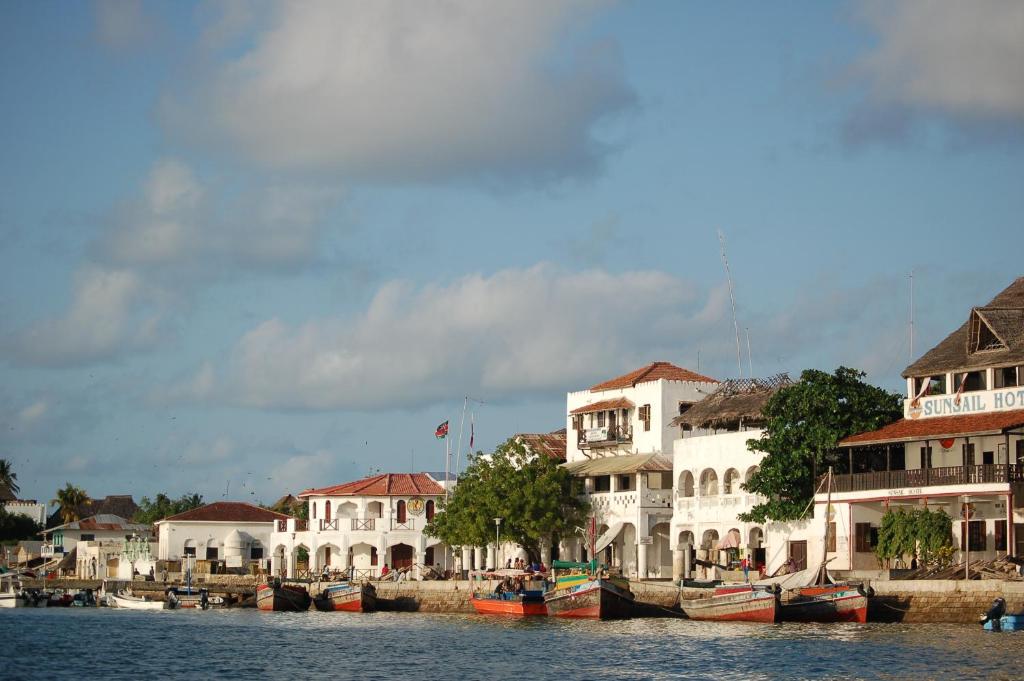 a group of white buildings next to the water at Lamu Sunsail Hotel in Lamu