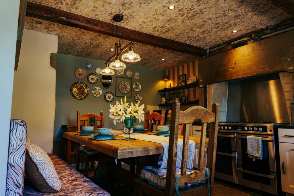 a kitchen with a wooden table and a dining room at Croft House Cottage in Halifax