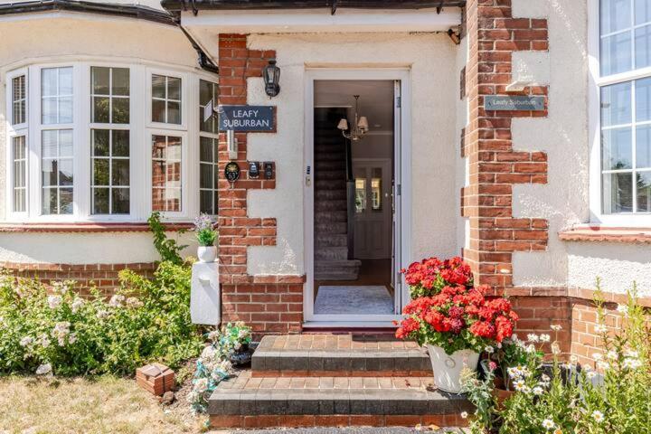 a brick house with a front door with flowers at Leafy Suburban Bed and Breakfast in Northwood