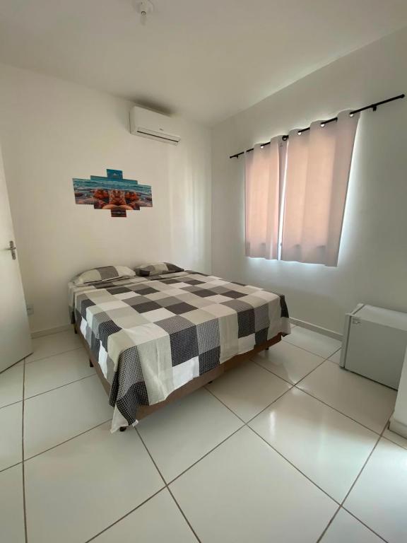 a bedroom with a bed in a white room at Refúgio da Praia in Caucaia