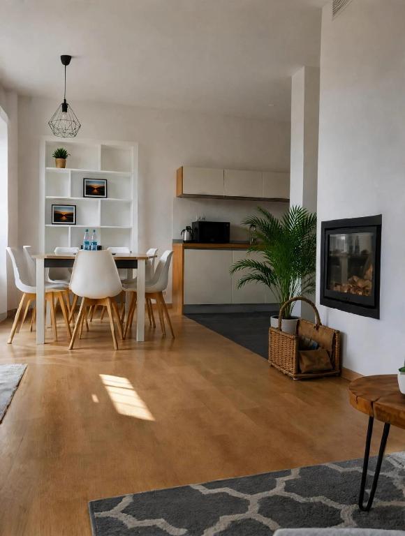 a dining room and living room with a table and chairs at Halna Residence in Krynica Zdrój