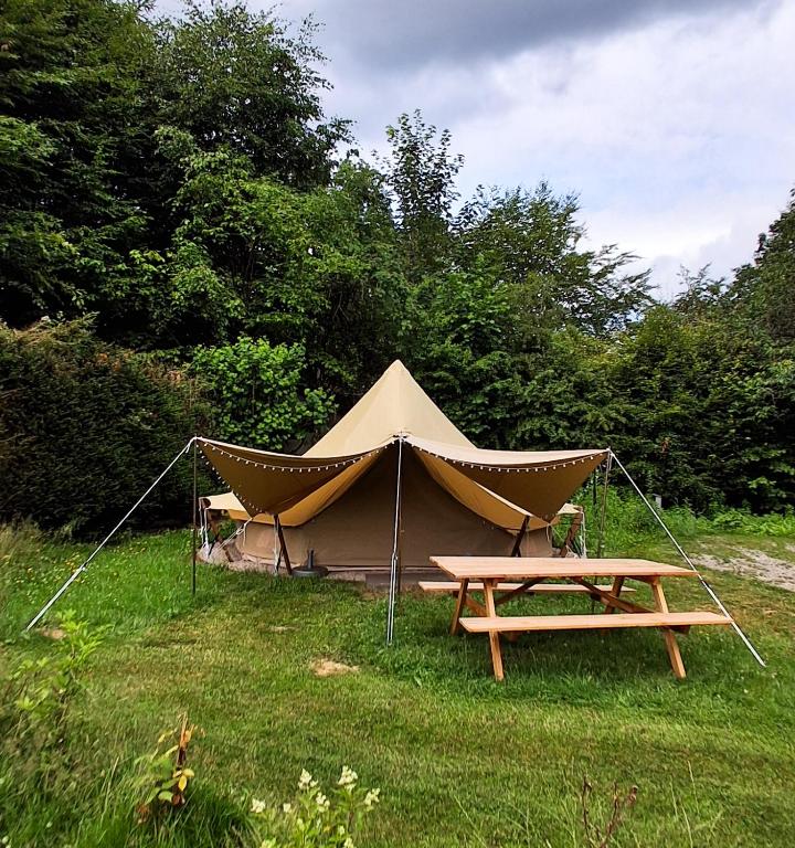 a tent with a picnic table in the grass at Tente équipée in Waimes