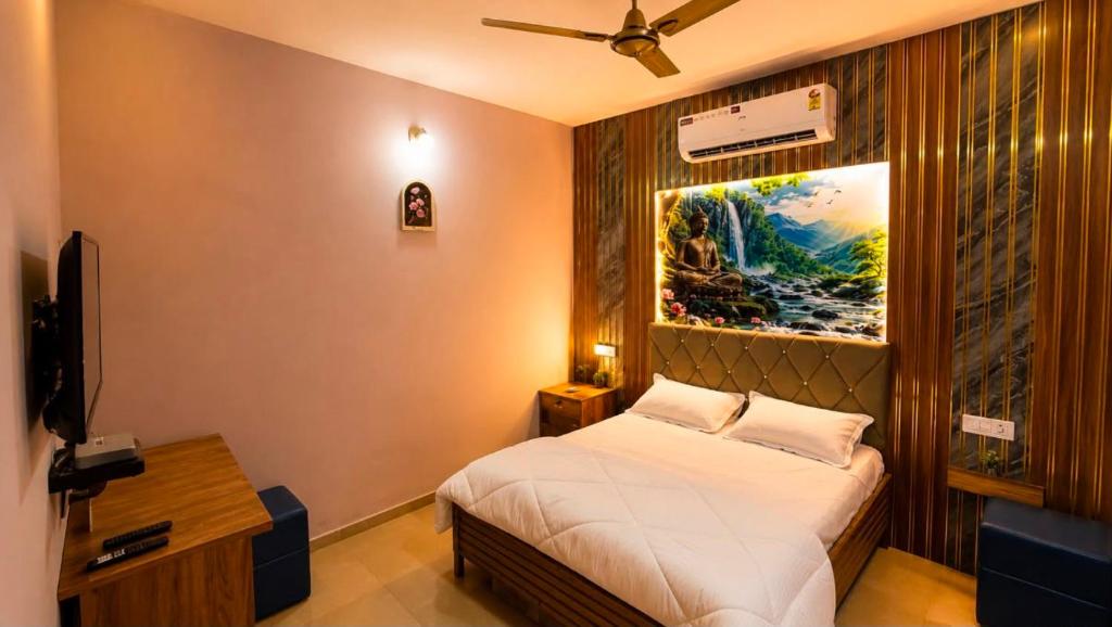 a bedroom with a bed and a painting on the wall at Hotel BABA DEEP SINGH RESTAURANT AND ROOMS in Ahmedabad