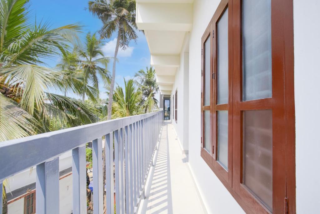 a balcony of a house with palm trees at Hotel O D'Rooms in Trivandrum