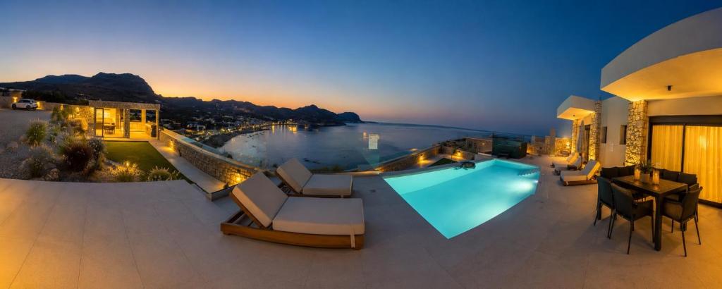 a house with a pool and a view of a river at Blue Infinito Boutique Villa, Infinity Pool , Heated Jacuzzi & Panoramic Sea View in Archangelos