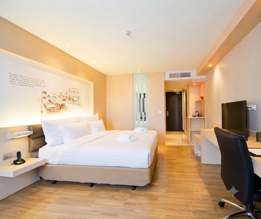 a bedroom with a bed and a desk and a television at Parinda Hotel - near Benjakitti Park & Queen Sirikit National Convention Center in Bangkok
